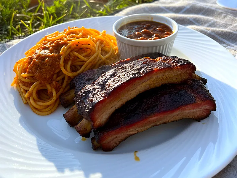 Rib plate with spaghetti and a ramekin of BBQ baked beans